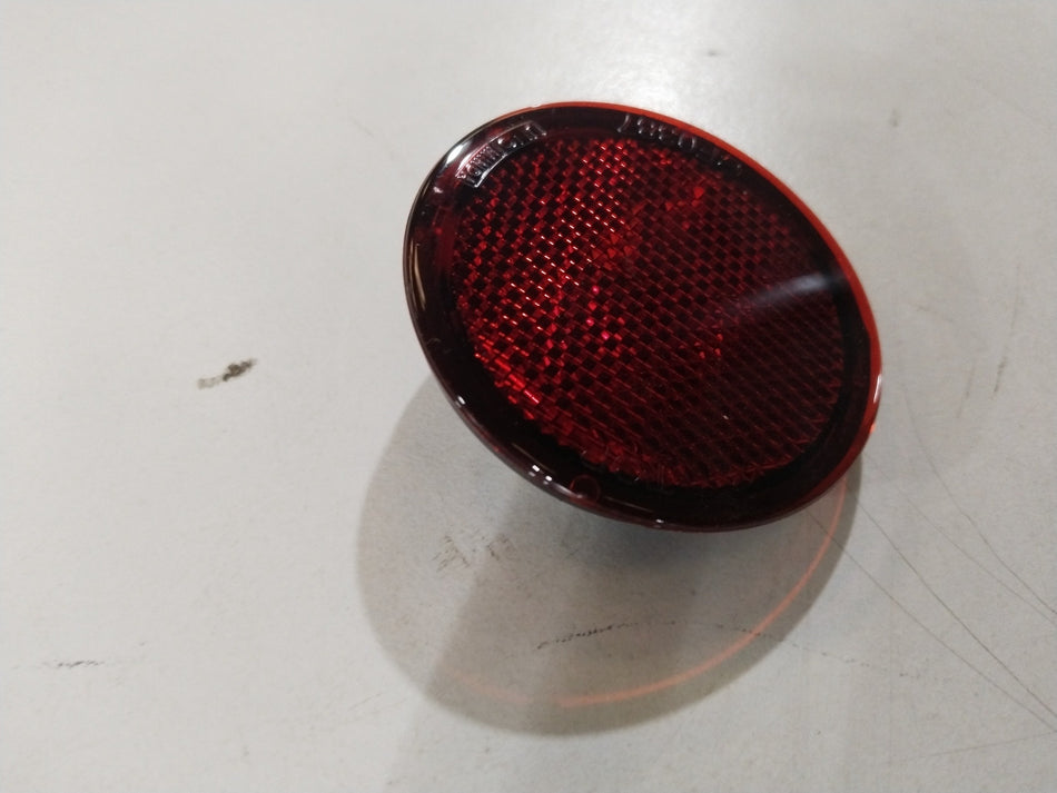 Nissan Kicks rear reflector part #265652XA0A showing the reflective surface and mounting area for vehicle rear protection.