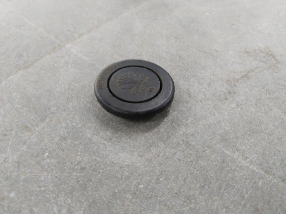 Chevrolet Optra engine plug by General Motors, close-up view showing the black plastic and metal components of the engine part.