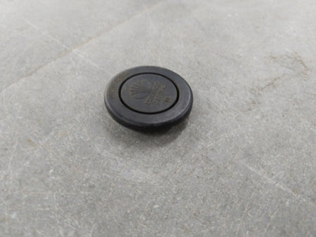 Chevrolet Optra engine plug by General Motors, close-up view showing the black plastic and metal components of the engine part.