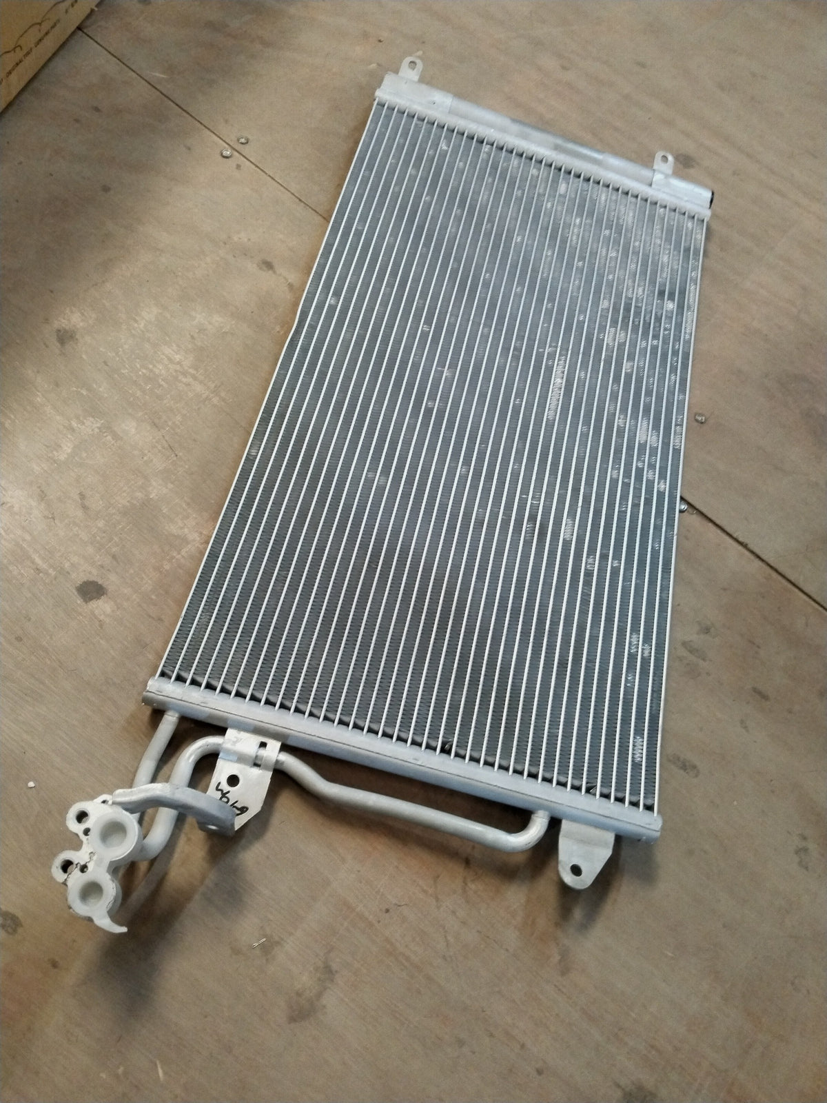 Volkswagen refrigerant condenser for Polo, Vento, Taigun, and Virtus models, showing the metal core and cooling fins.
