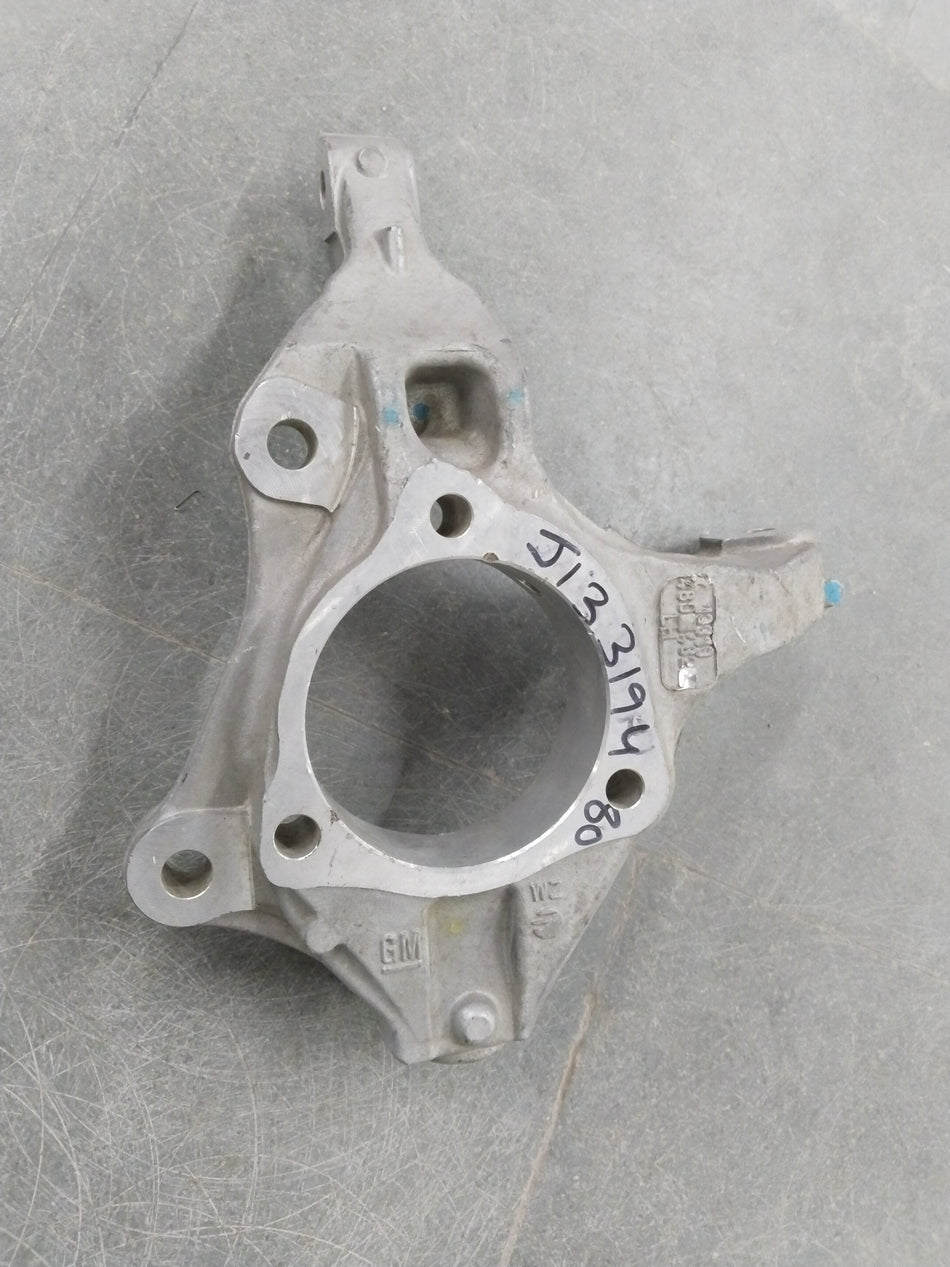 General Motors Chevrolet Cruze steering knuckle, metallic component with bolt holes, designed for vehicle suspension and steering system.