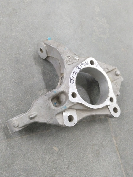 Chevrolet Cruze steering knuckle by General Motors, showing the metal component with mounting points and bolt holes.