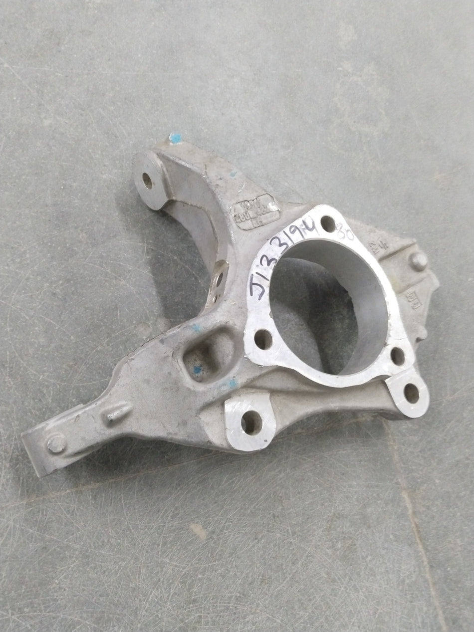 Chevrolet Cruze steering knuckle by General Motors, showing the metal component with mounting points and bolt holes.