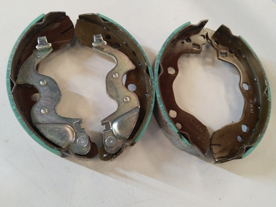 Rear brake shoe for Maruti Suzuki Ertiga, model #53200M72R01, showing the metal friction surface and overall shape.