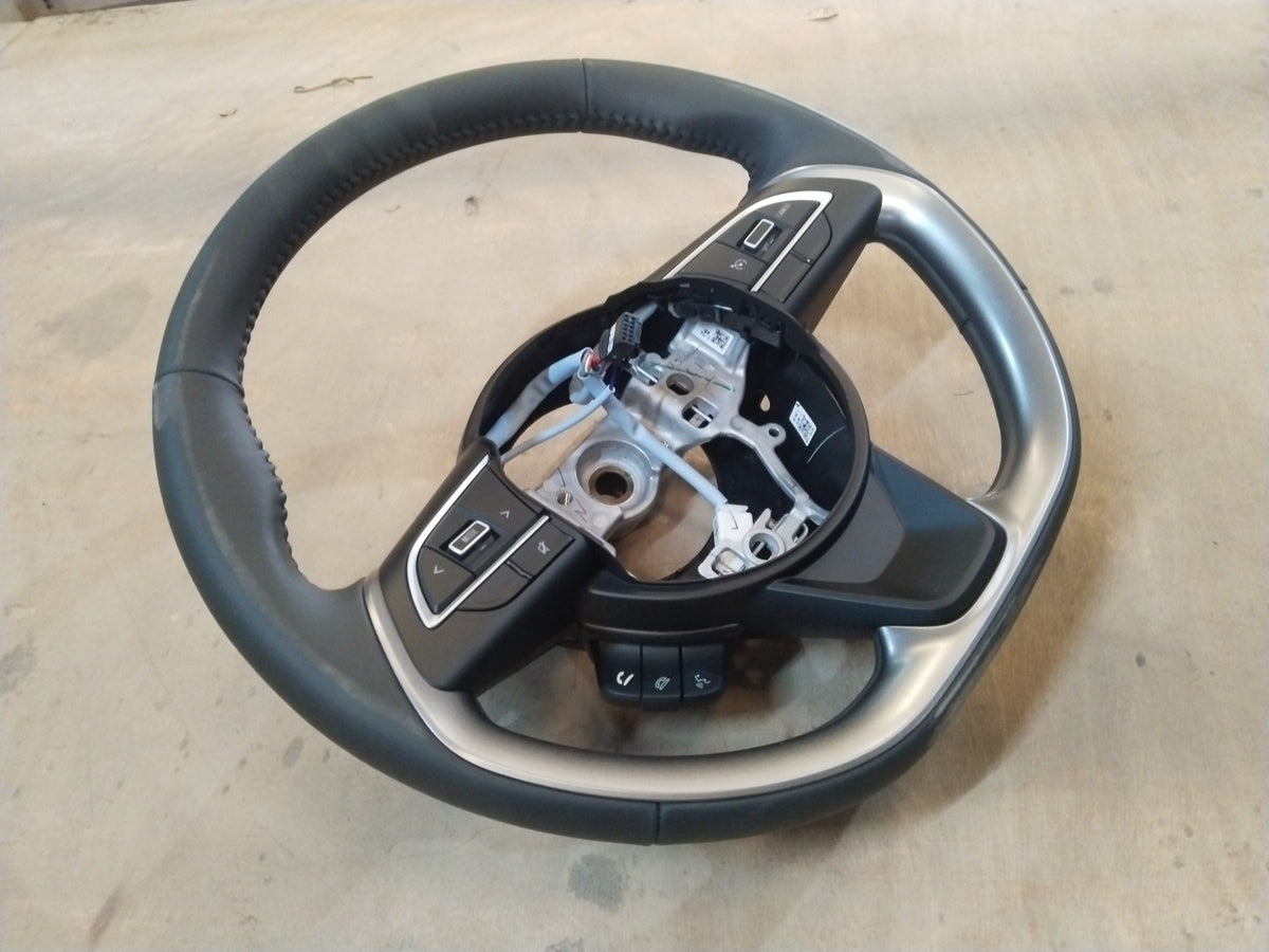 Maruti Suzuki Brezza 2nd Gen steering wheel for petrol and CNG models, black with mounted controls, close-up view.