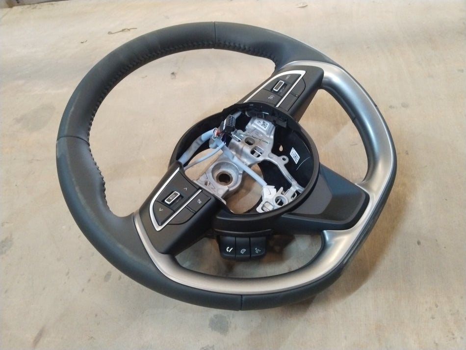 Maruti Suzuki Brezza 2nd Gen steering wheel for petrol and CNG models, black with mounted controls, close-up view.