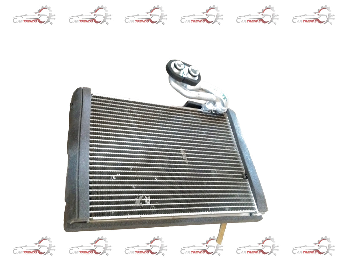 Maruti Suzuki EVAPORATOR SUB ASSY 95411M56R00 showing the automotive air conditioning component with metal fins and connectors.