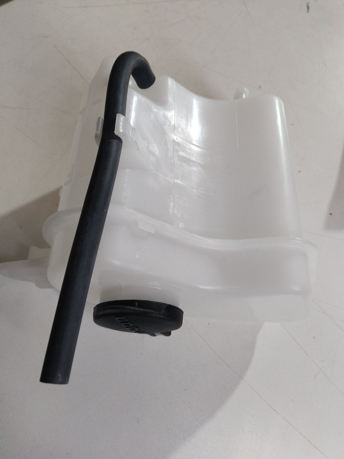 Hyundai Grand i10 expansion tank coolant bottle showing the plastic reservoir with cap for engine cooling system.