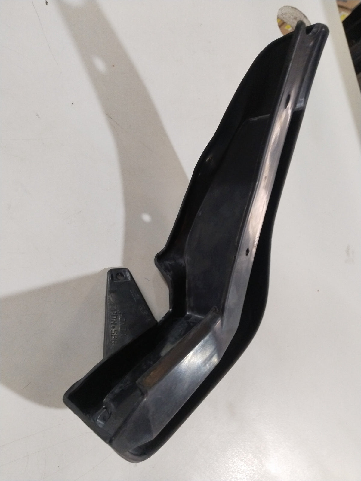 CarTrends city mud guard for left rear wheel, showing close-up view of black plastic mud guard attached to vehicle