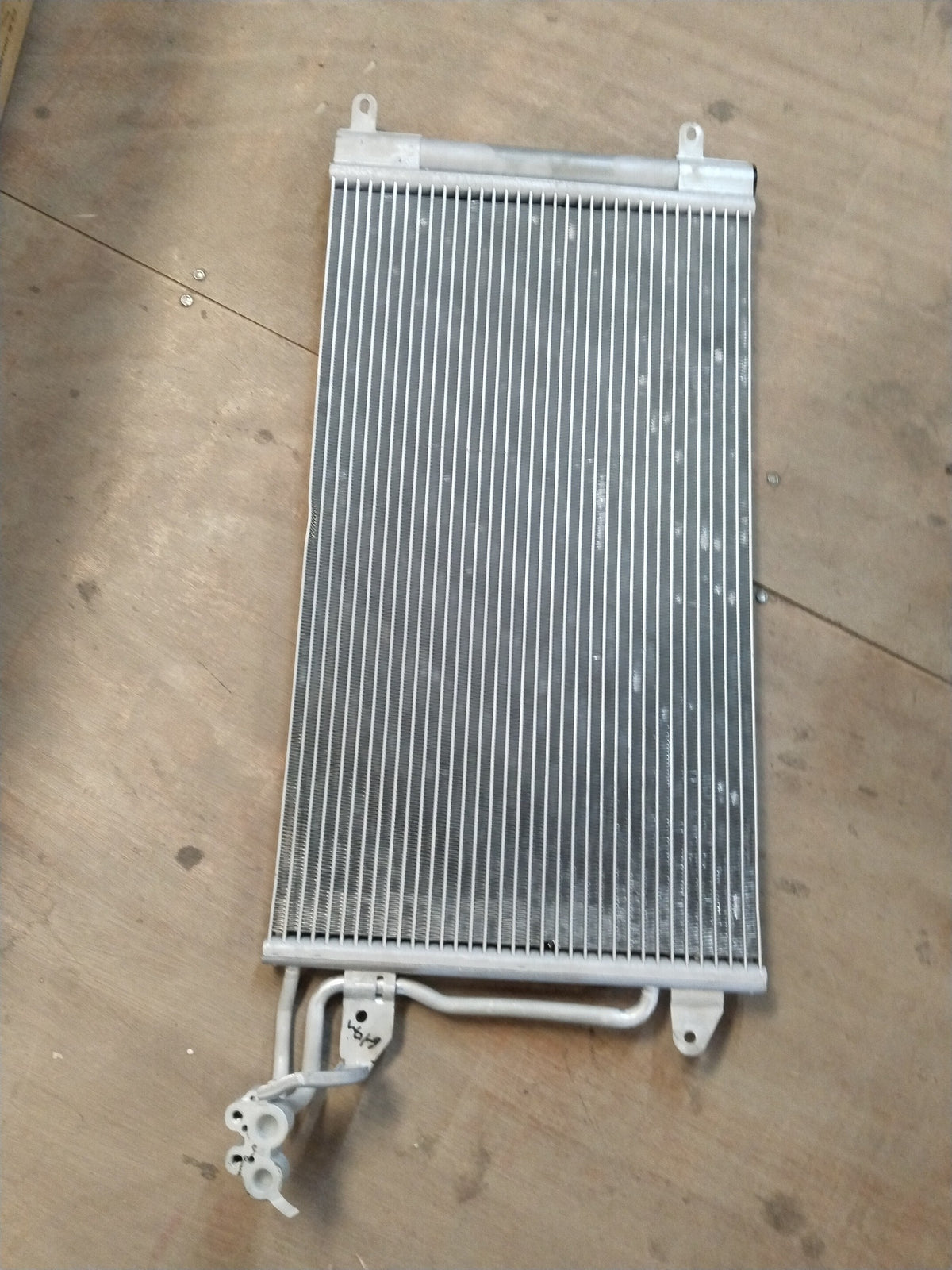 Volkswagen refrigerant condenser for Polo, Vento, Taigun, Virtus models, showing metal fins and connection points.