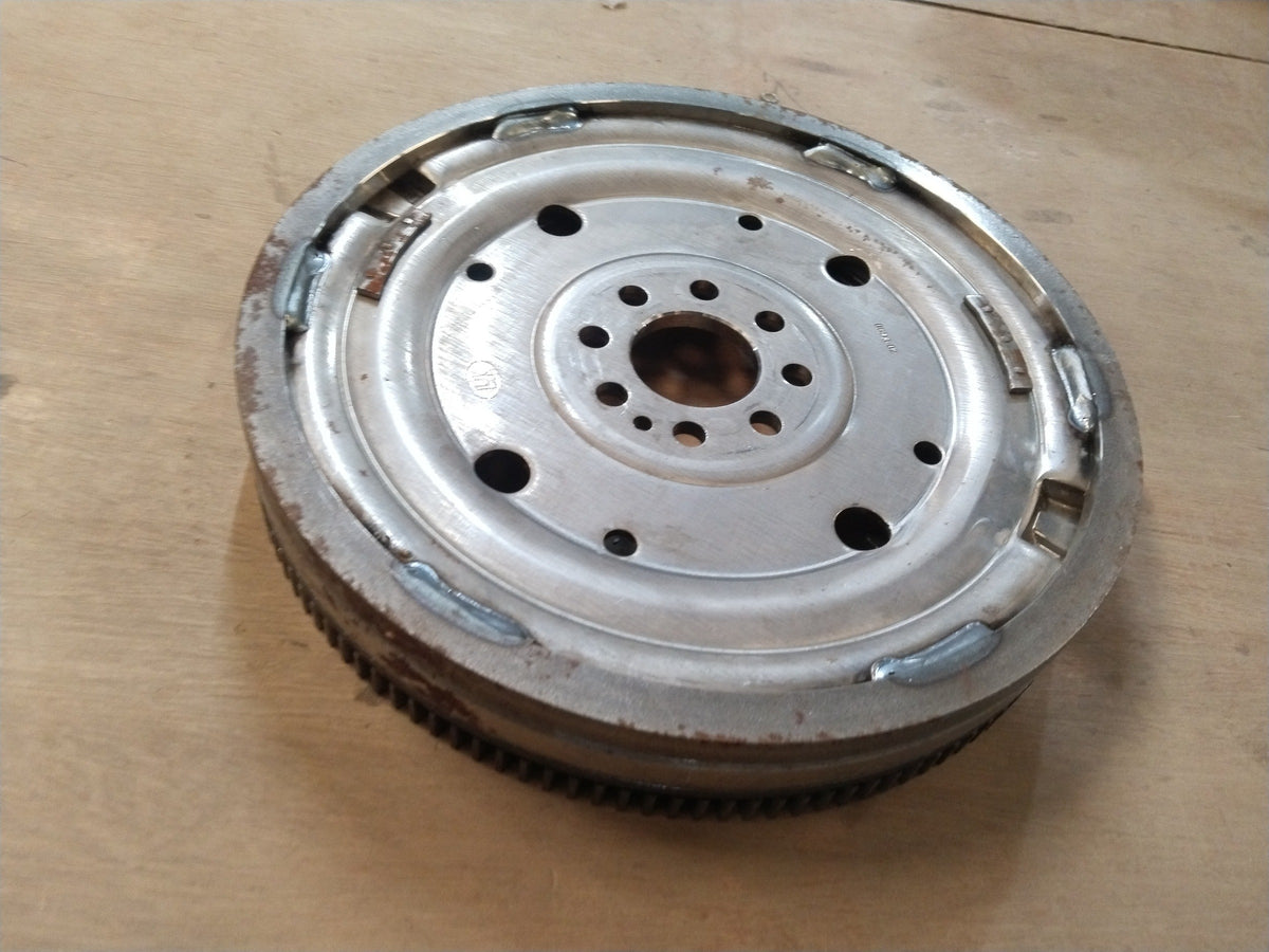 Volkswagen flywheel for Tiguan, Octavia, and Superbe models, showing the metal disc with gear teeth and mounting holes.