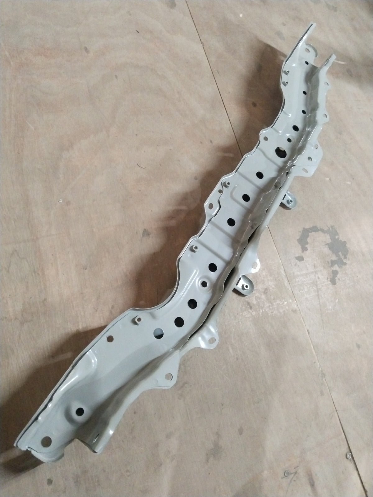 Maruti Suzuki S-Presso hood lock member in black, showing the metal latch and mounting components for engine bay security.