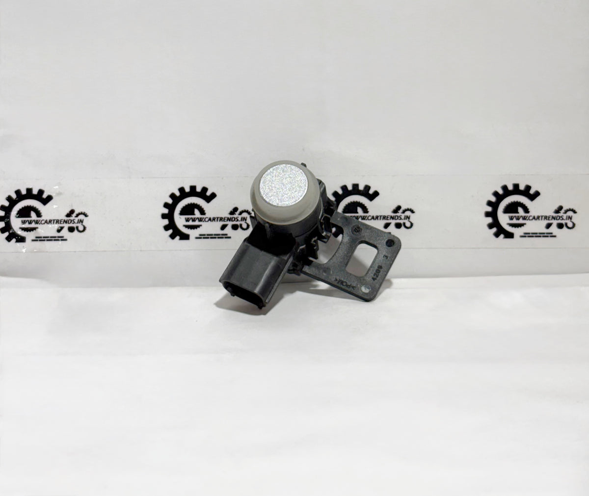 Honda parking sensor assembly with clip, shown on the front of the vehicle in a close-up view.