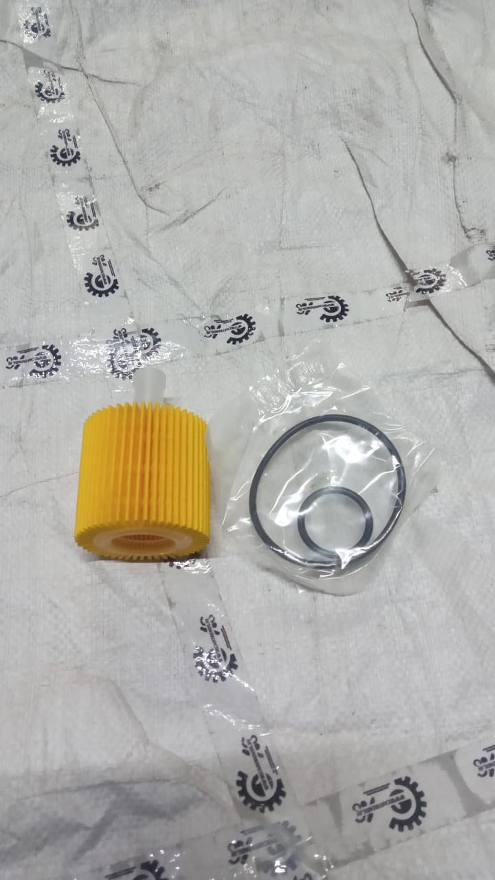 Aftermarket oil filter for Toyota Corolla TL, shown as a black cylindrical filter with a metal top and rubber seal.