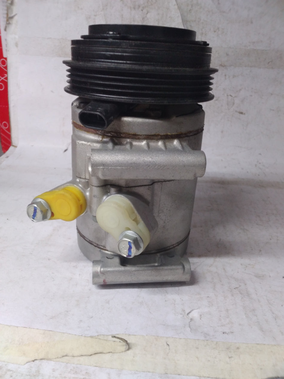 General Motors AC compressor Spark J96858724, automotive air conditioning component with metal and plastic parts.