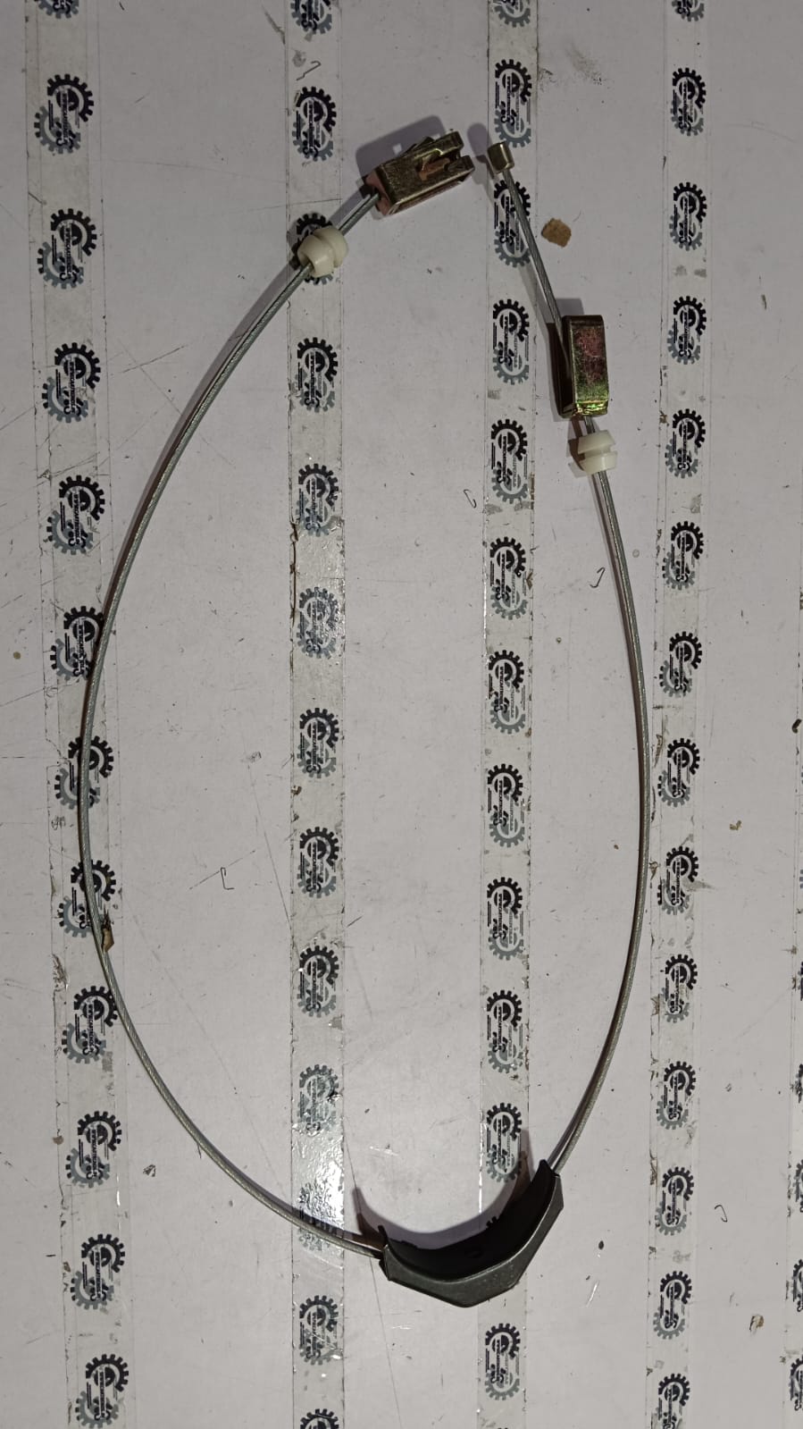 General Motors Tavera parking brake cable showing the black cable with metal connectors for vehicle braking system