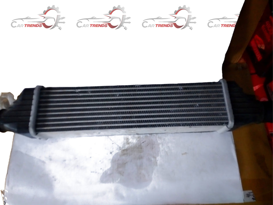 General Motors cooler assembly with air sail, part J90870773, for vehicle cooling system, shown from the front angle.