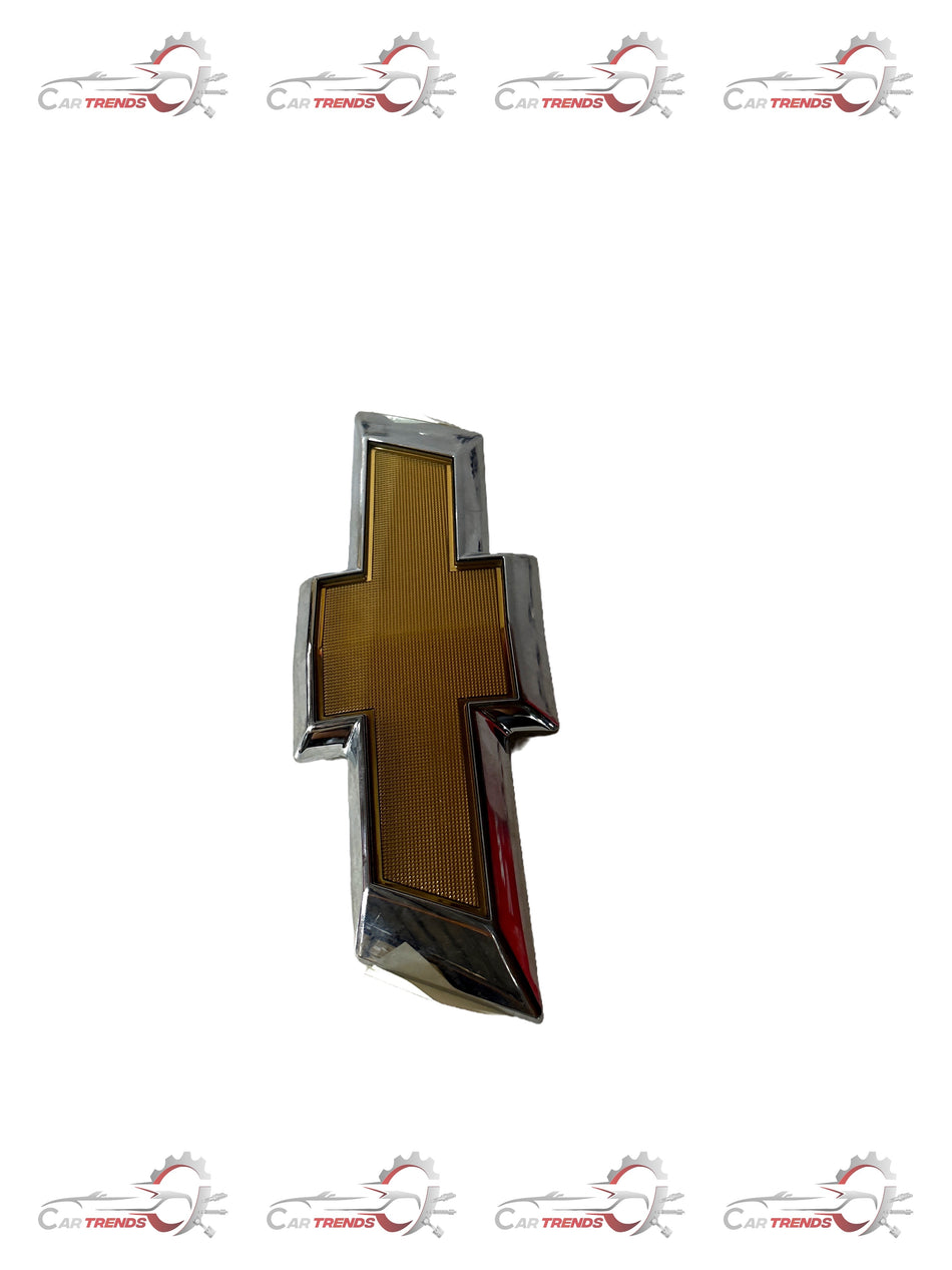General Motors emblem assembly for front fascia, part J95122572, featuring a sleek badge design for vehicle branding.