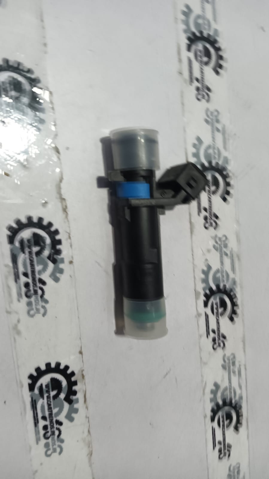 General Motors injector port fuel sail HB J24101262, black plastic component for fuel system, detailed close-up image.