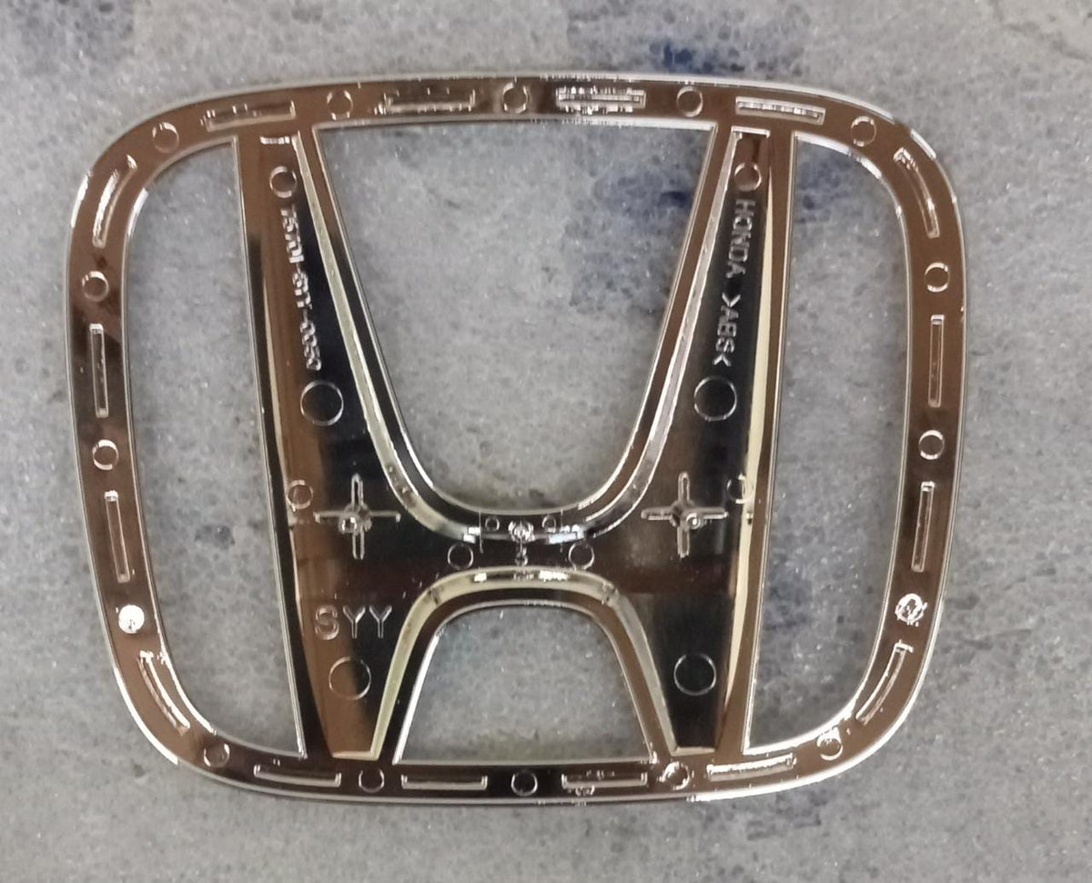 Honda emblem badge featuring the Honda logo, designed for vehicle identification and branding on Honda cars.