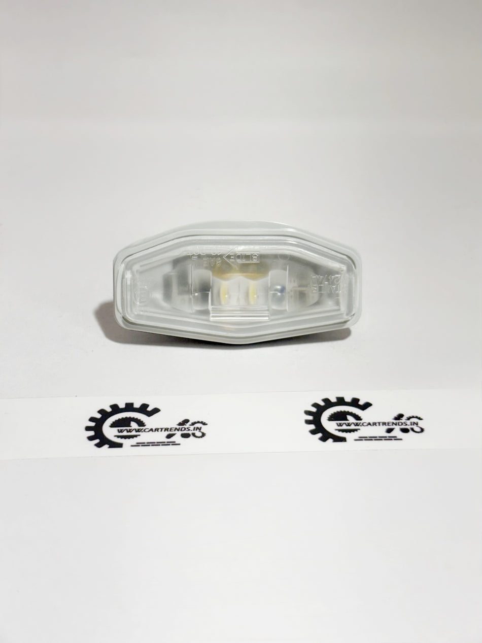 Honda license light assembly model 34100T9A003, showing the rear view with clear lens and mounting brackets.