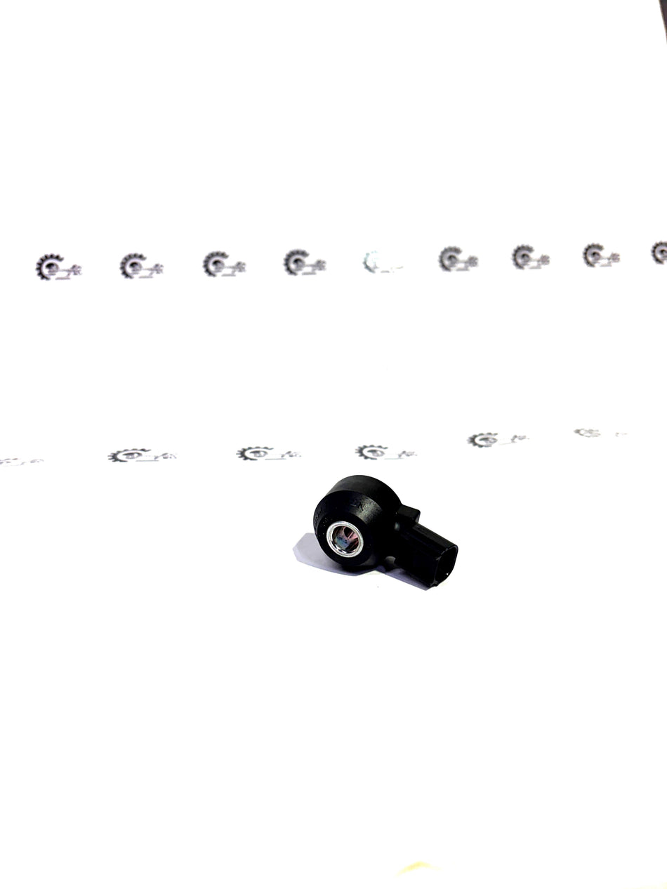 Honda SENSOR.KNOCK 30530R1AA01 engine knock sensor mounted on engine block, black cylindrical component with wiring.