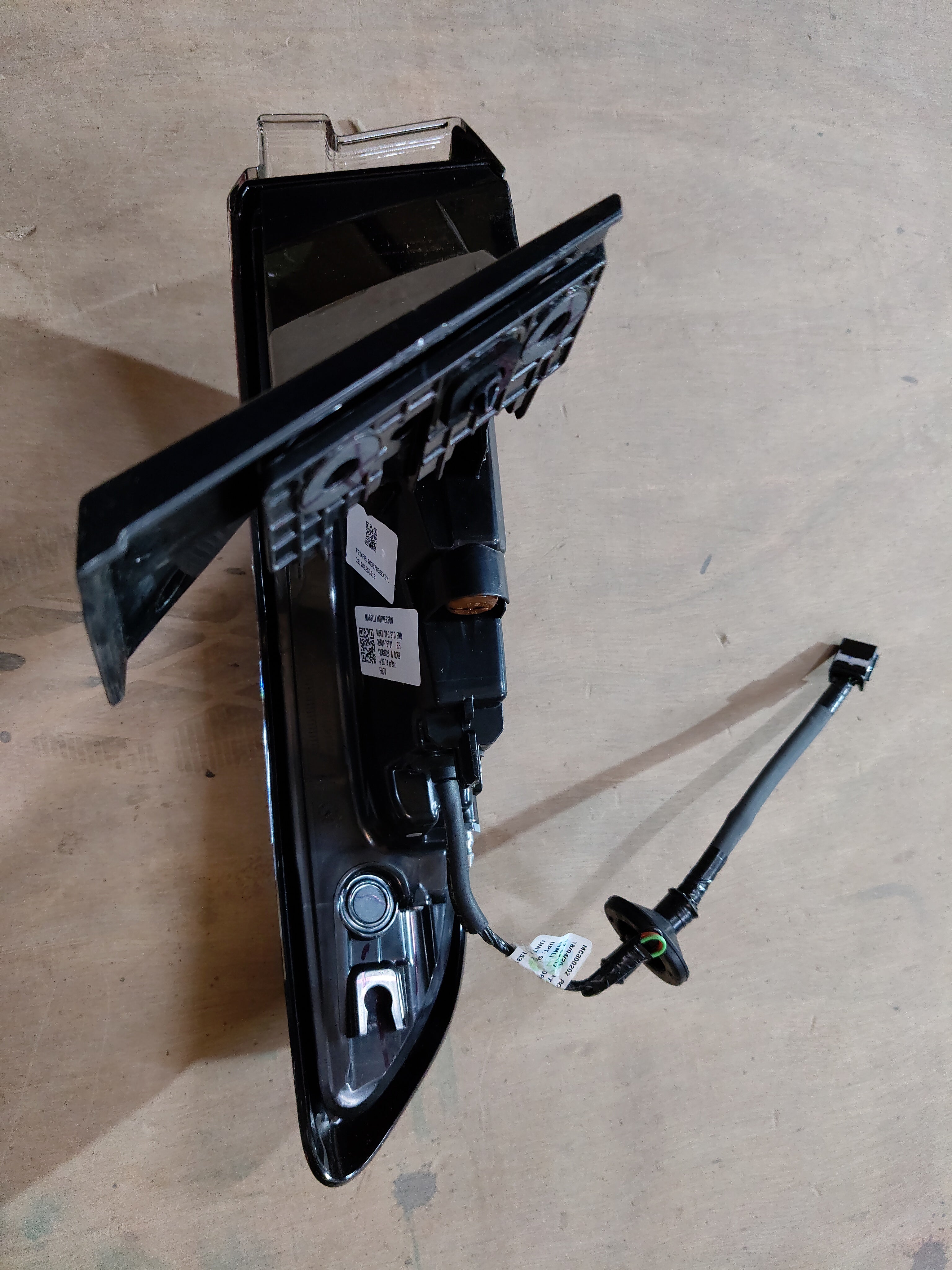 Maruti Suzuki tail and stop lamp assembly, model 35801M76T01, showing the automotive rear light with clear lens and electrical connectors.