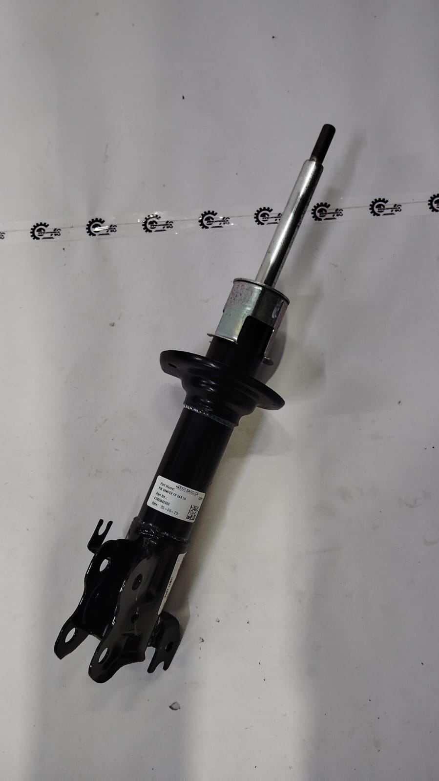 Maruti Suzuki front strut assembly for suspension, showing the shock absorber and spring components.