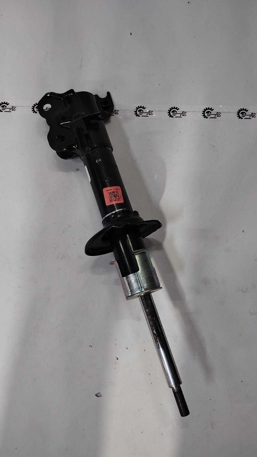 Front strut assembly for Maruti Suzuki vehicle, showing the suspension component with coil spring and mounting points.