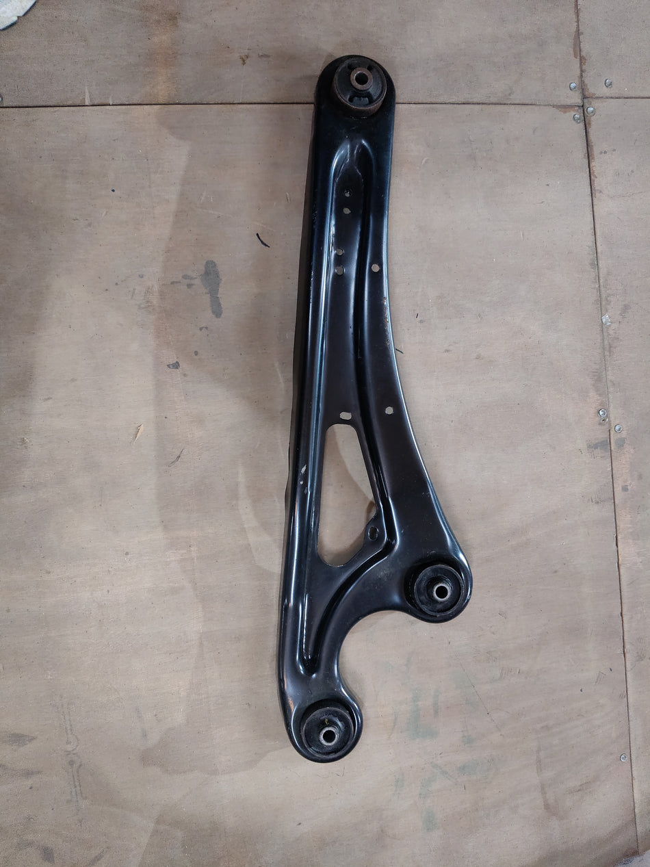Maruti Suzuki rear trailing arm assembly with part number 46201M67L00, showing the metal arm component on a plain background.