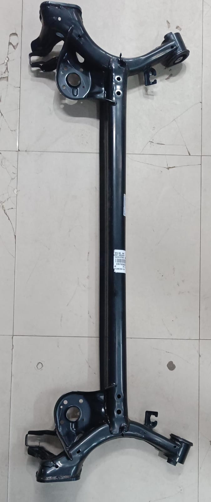 Maruti Suzuki dead axle beam for Wagon R, part number 46500M69R00, shown in a detailed view of the rear suspension component.