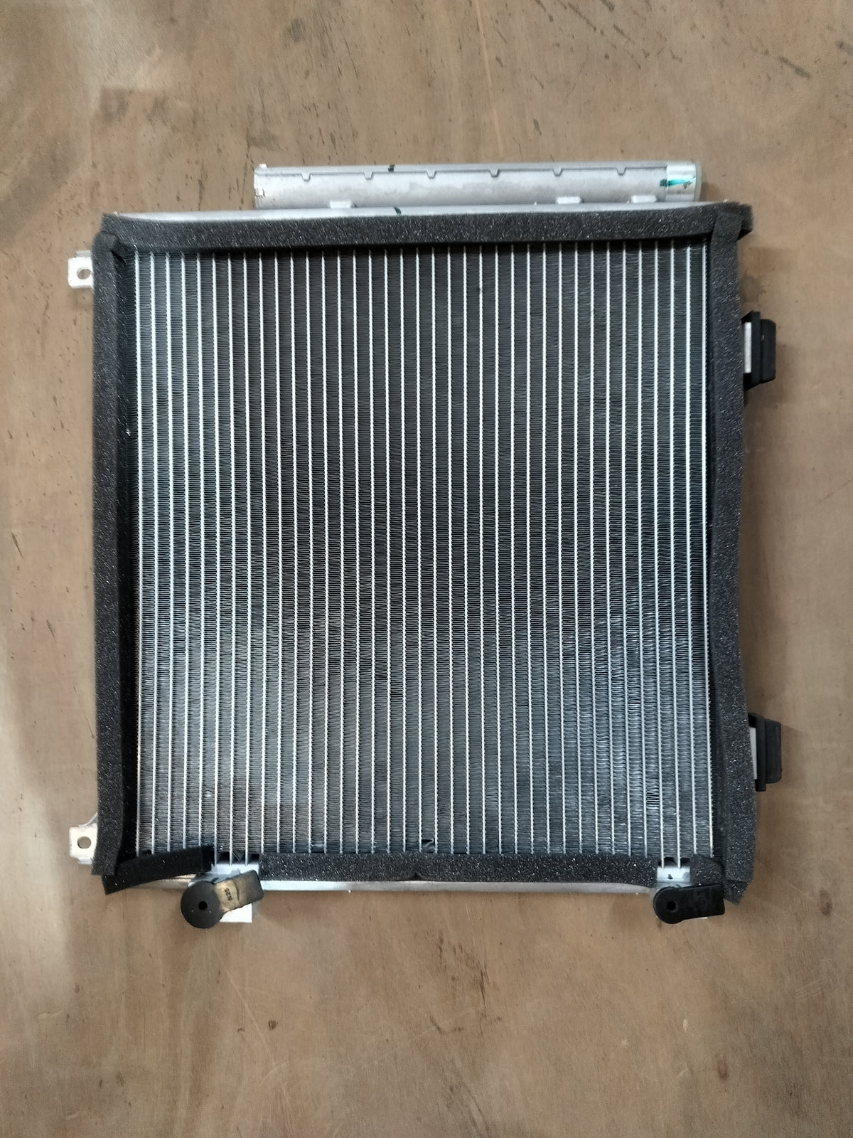 Maruti Suzuki condenser assembly 95310M67L00, automotive cooling component with metal fins and connector, for vehicle air conditioning.
