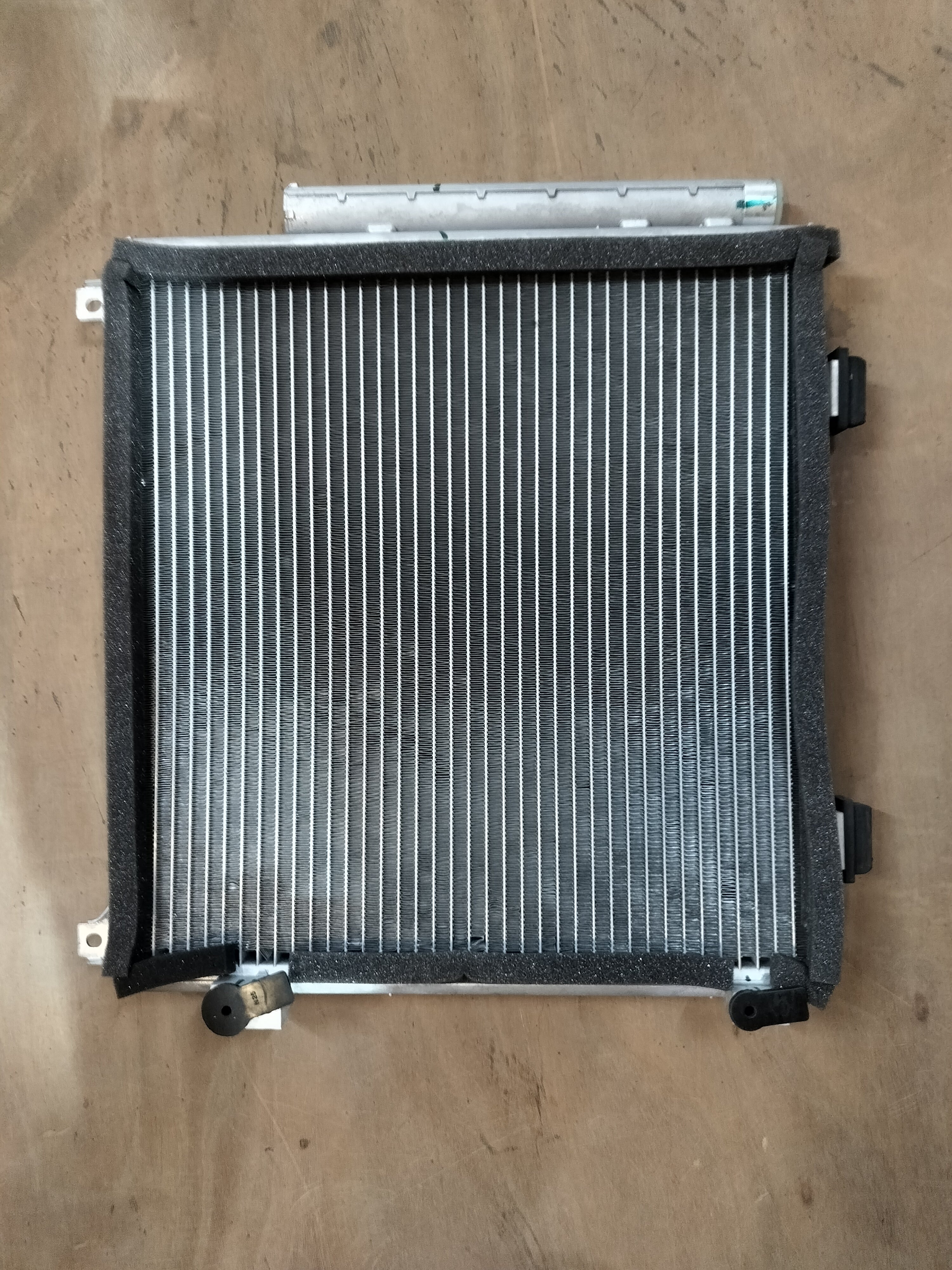 Maruti Suzuki condenser assembly 95310M67L00, automotive cooling component with metal fins and connector, for vehicle air conditioning.
