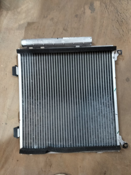 Maruti Suzuki condenser assembly part number 95310M67L00, automotive cooling component with metal fins and connectors.