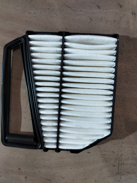 Maruti Suzuki Element Air Cleaner 13780M66R50 installed in a vehicle engine compartment, showcasing the brand and product details.