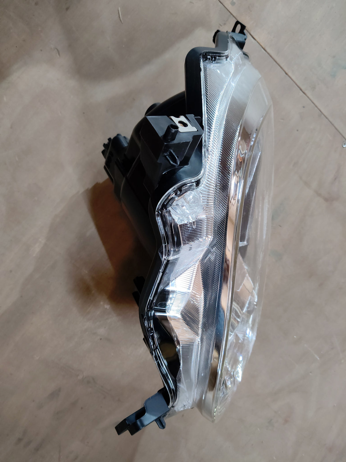 Maruti Suzuki Ignis head lamp assembly, model 35121M66R10, showing the front view with clear lens and mounting bracket.