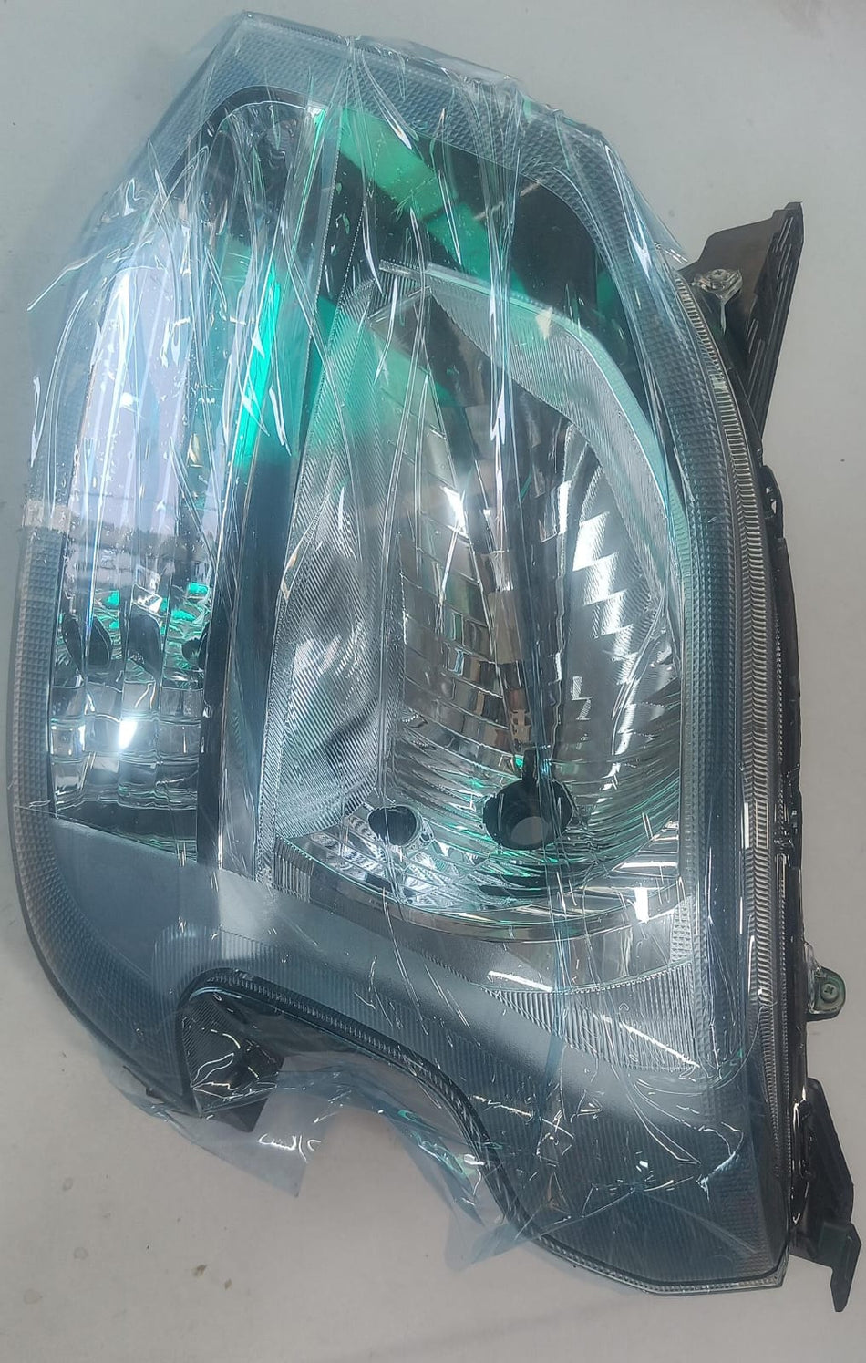 Maruti Suzuki head lamp Waganr 35321M69R00 showing the front view of the vehicle's headlight assembly.