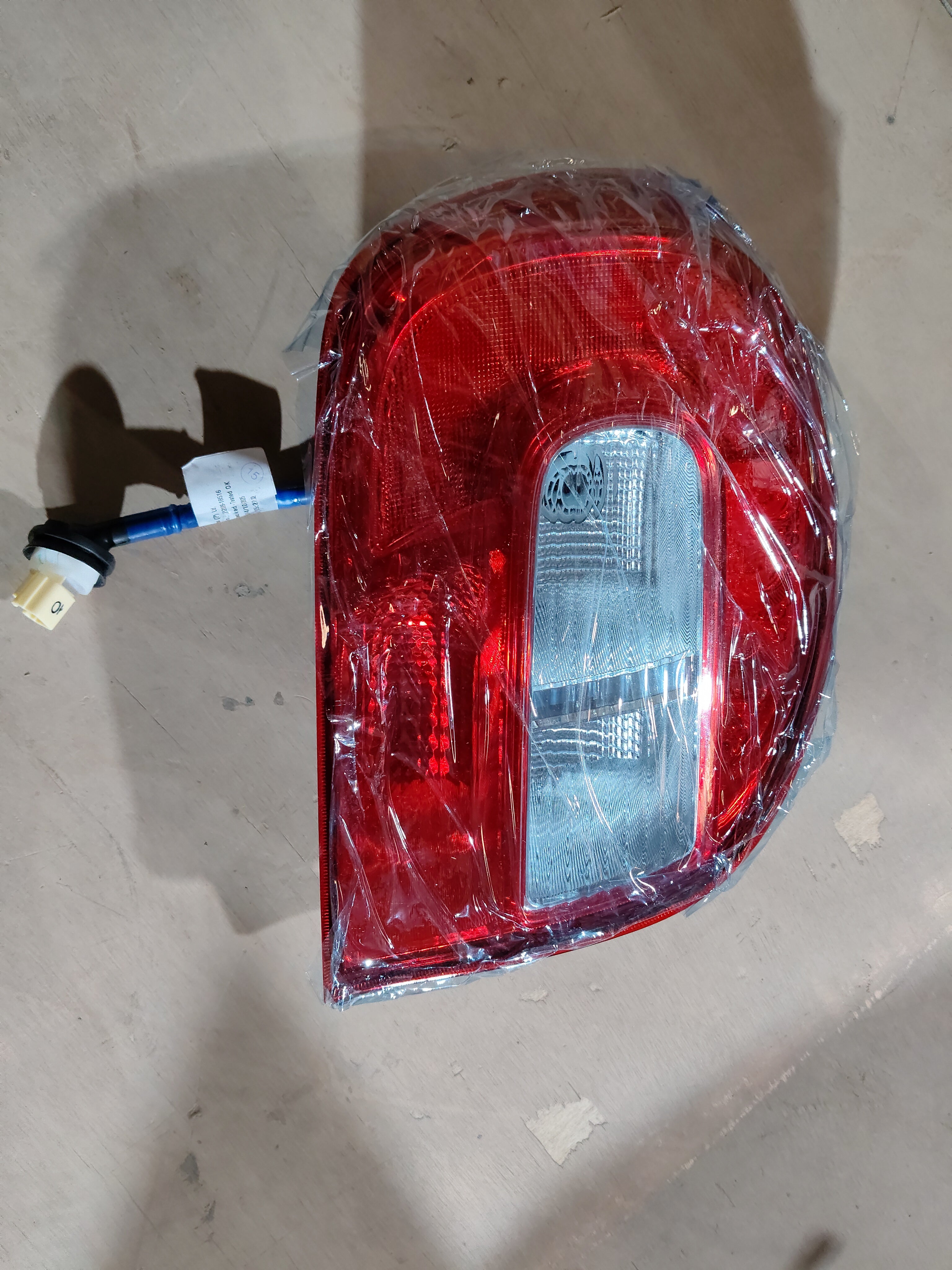 Maruti Suzuki rear combination lamp unit for Alto K10, left side, automotive lighting component with clear lens and wiring.
