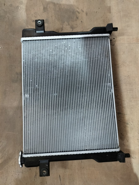 Maruti Suzuki radiator assembly 17700M77PB0 showing the core and mounting brackets for vehicle cooling system.