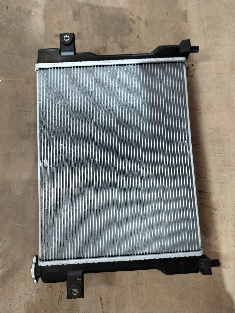 Maruti Suzuki radiator assembly 17700M77PB0 showing the core and mounting brackets for vehicle cooling system.
