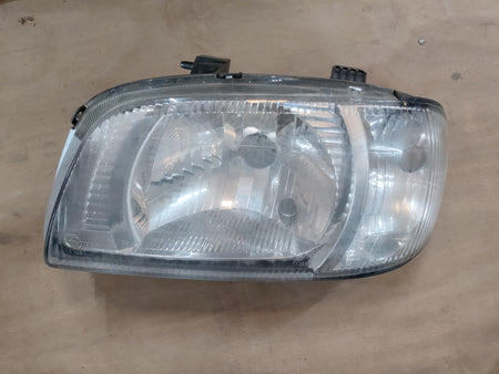 Maruti Suzuki Alto Minor headlamp assembly, black plastic housing with clear lens for vehicle illumination.