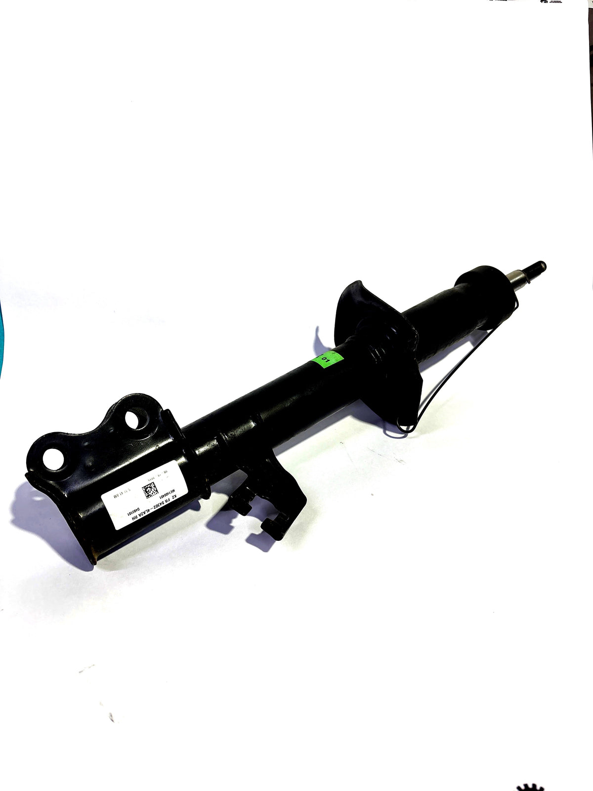 Nissan Datsun Go front right shock absorber, OEM part, showing the metal shock component mounted on the vehicle suspension.