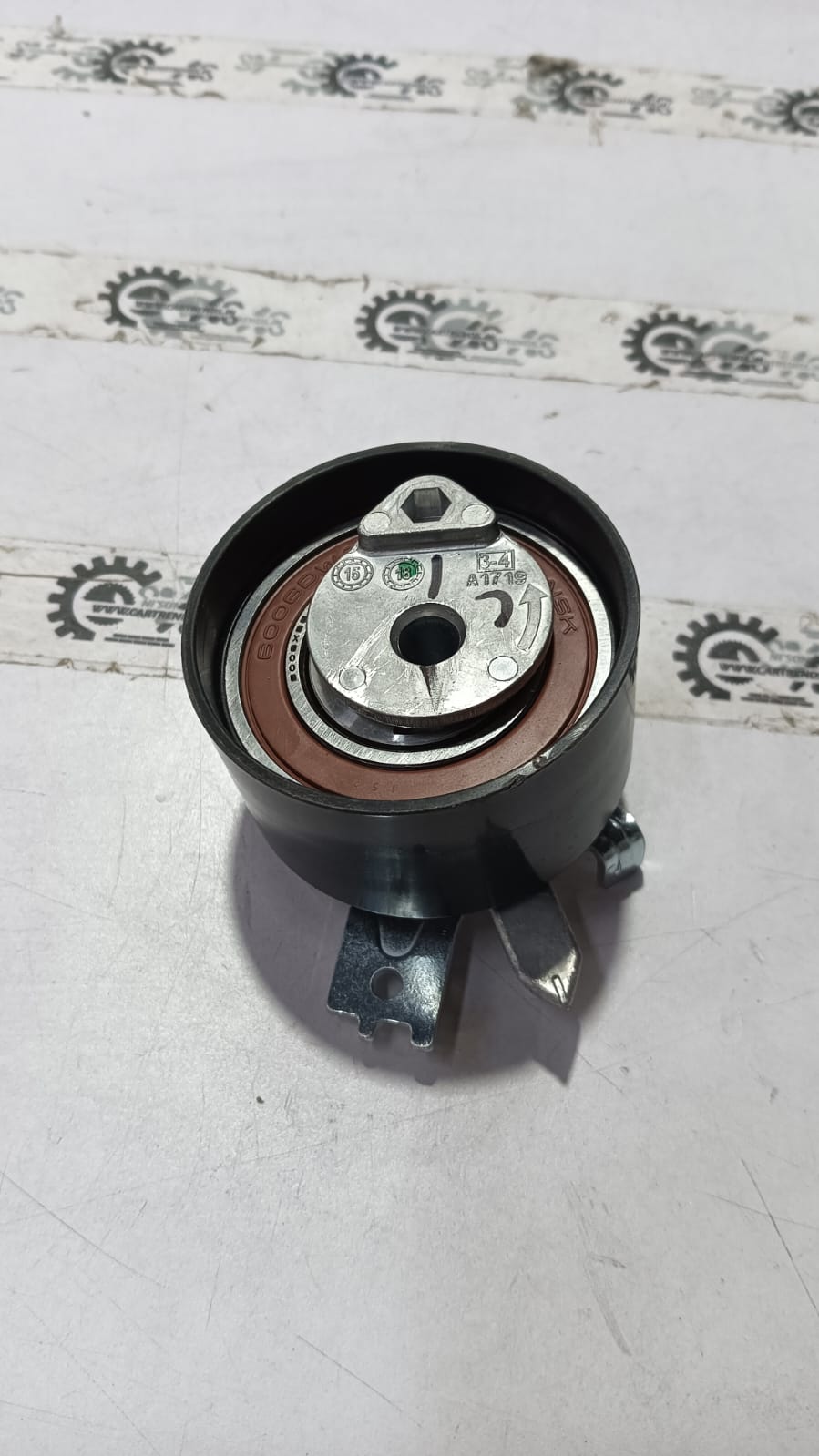 Nissan tensioner assembly for Mahindra Verito engine, part number 1680600QBBMK, shown in a detailed close-up image.