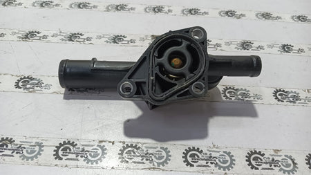 Nissan Kwid thermostat housing part 110600318R, showing the black plastic component with mounting details.
