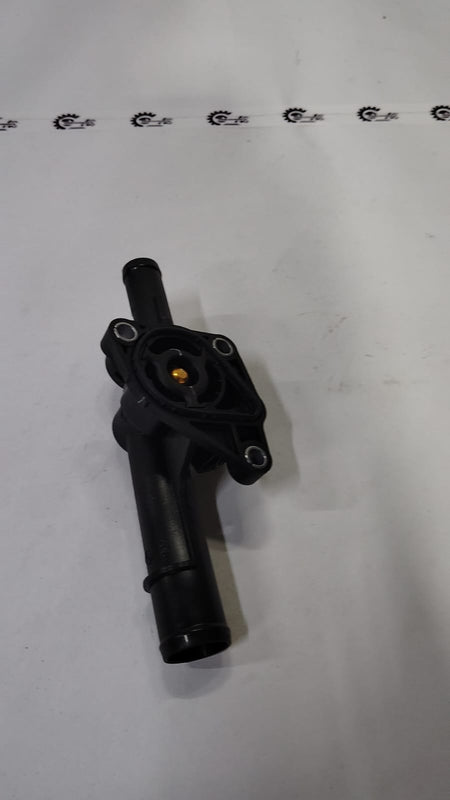 Nissan Kwid thermostat housing part 110600318R, shows the black plastic component with mounting points and connectors.