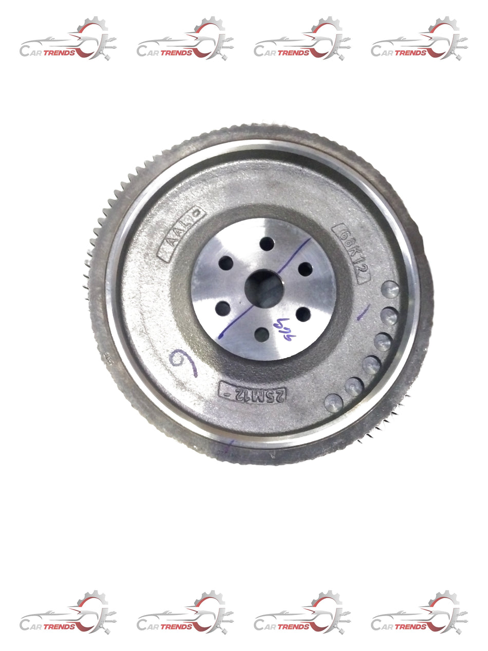 Maruti Suzuki flywheel component labeled FLYWHEEL COMP 12620M68K12, showing a metallic automotive part with detailed surface features.