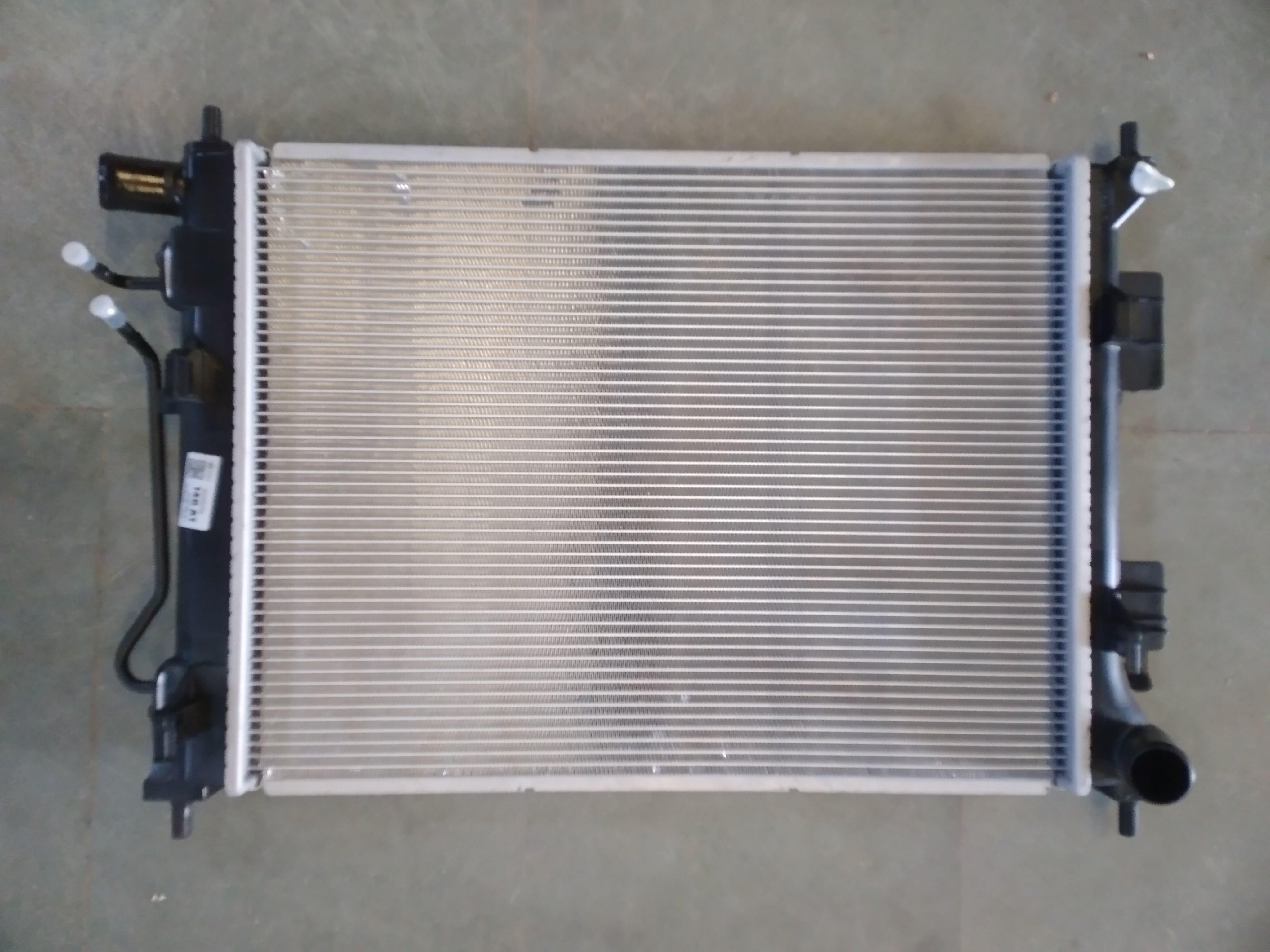 Hyundai 253100u050 radiator for petrol Xcent, new model, showing the metal core and inlet/outlet connections.