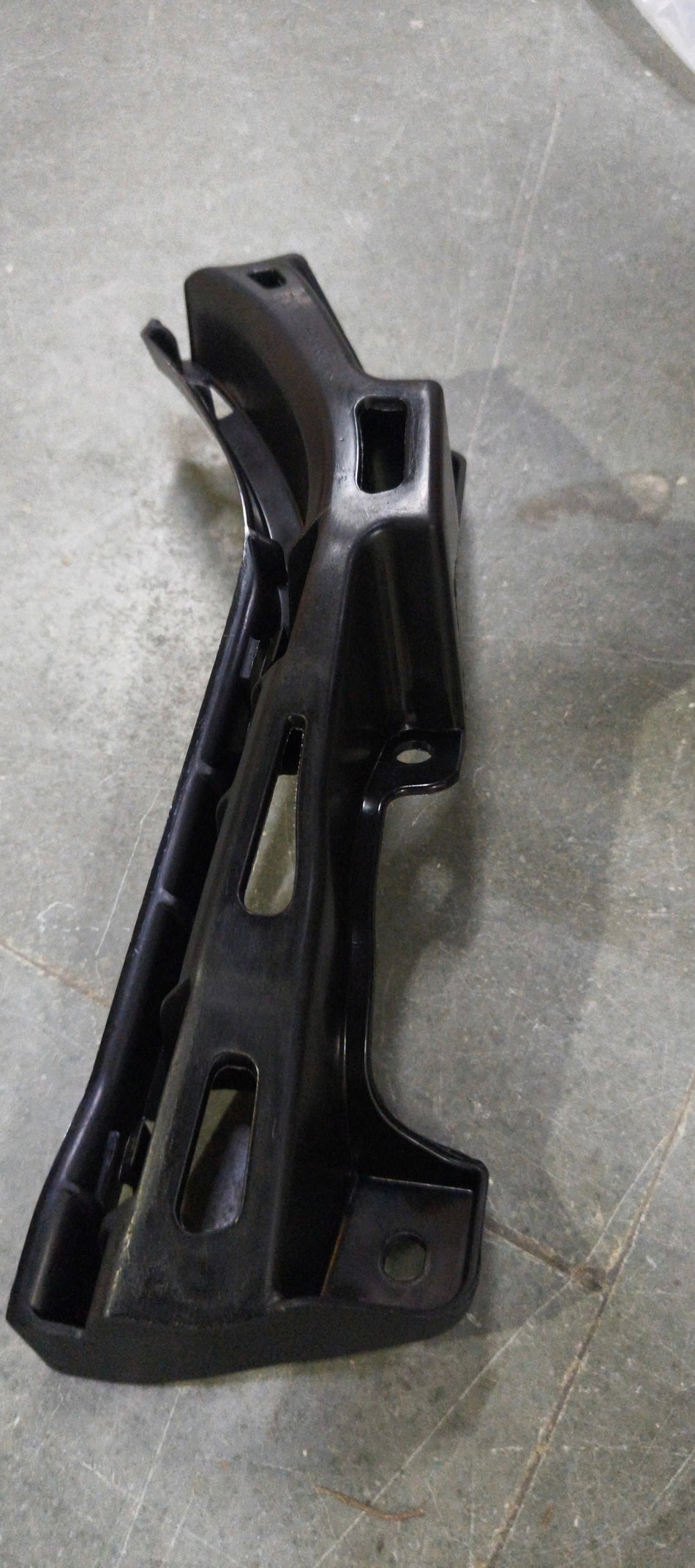 Maruti Suzuki front bumper holder part 71733M55R00, close-up view showing the sturdy plastic component for vehicle assembly