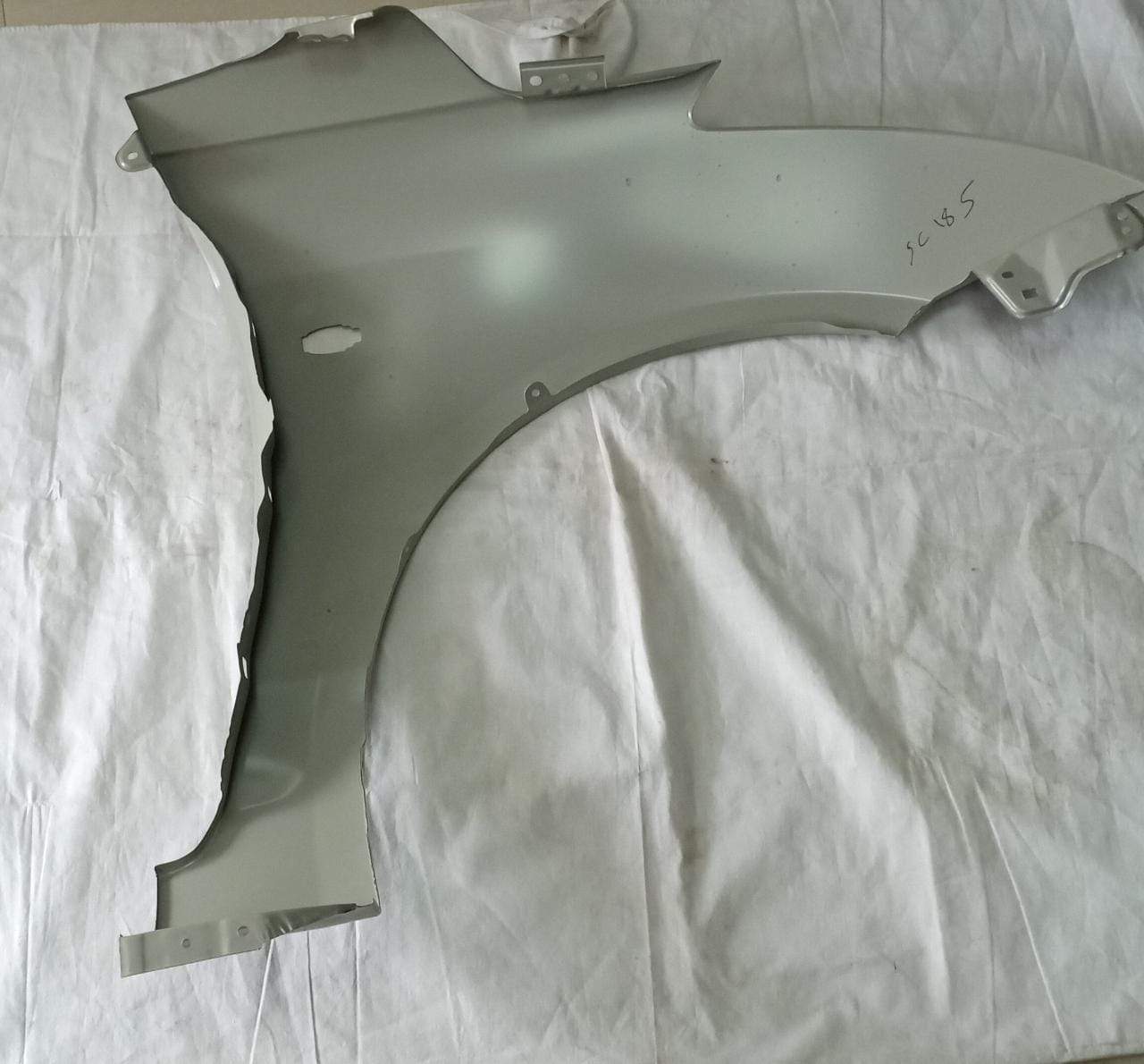 CarTrends Fender Swift 2018 front left side spare part, close-up of the black automotive fender for car repairs.
