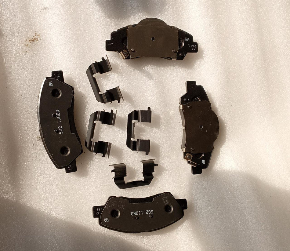 CarTrends front brake pad for 2010 Grand, close-up of new spare parts brake pad with metal backing and friction surface.